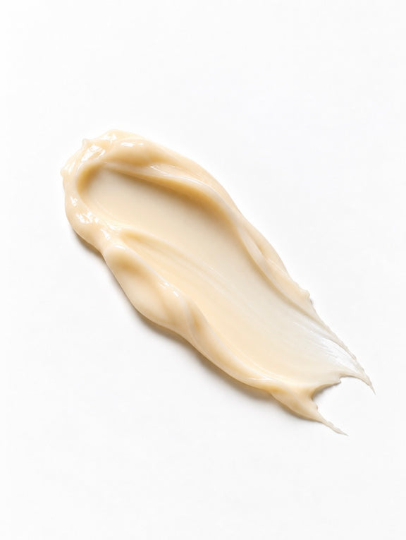 A thick, creamy smear of beige cosmetic cream or lotion on a clean white background.